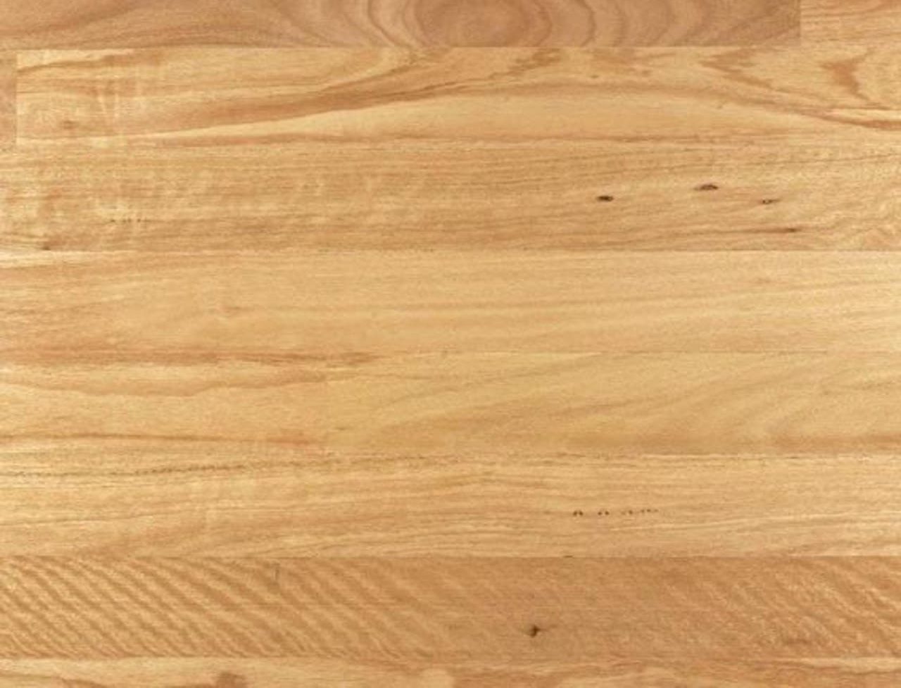 Light-colored wooden floor with visible natural grain patterns and subtle variations in tone, showing a smooth, polished surface.